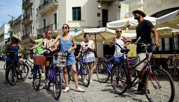 Varios turistas usan bicicletas en el centro histórico de La Habana
