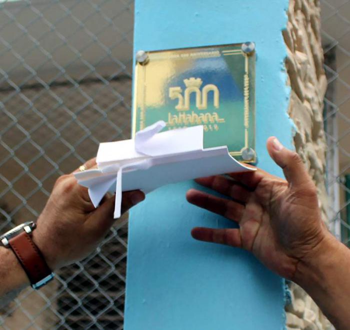 Hombre colocando placa por el aniversario 500 de La Habana.