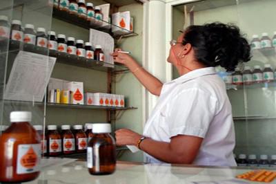 Farmacéutica en una farmacia localiza medicamentos en un estante