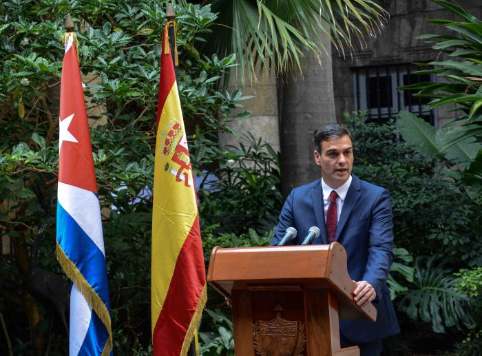 hombre, tribuna, bandera cubana, bandera española, arbustos, edificio