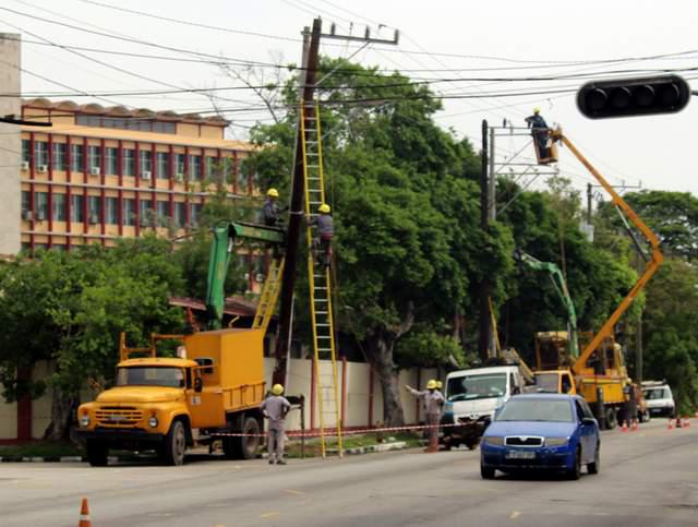 trabajadores de al empresa eléctrica, durante su trabajo en una calle habanera.