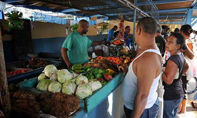 Personas compreando viandas y hortalizas en un mercado habanero.