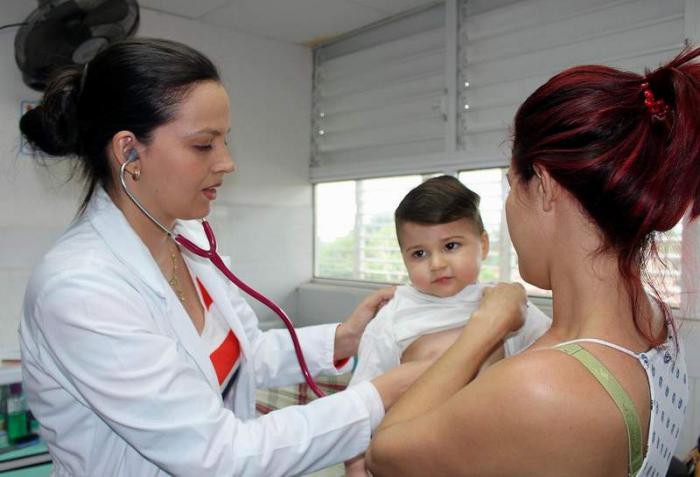 Doctora atendiendo a un niño en hospital cubano.