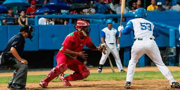 La imagen muestra a 4 personas, un bateador, un catcher, un árbitro y un jugador esperando