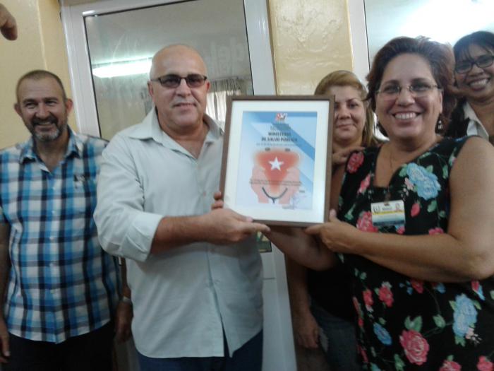 Dos personas sostienen un diploma durante los festejos por el Día de la Medicina Latinoamericana en La Habana.