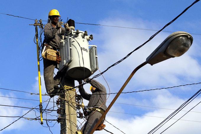 la imagen muestra dos personas trabajando con el tendido eléctrico