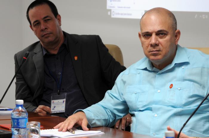 dos hombres, mesa, micrófono, pomo de agua