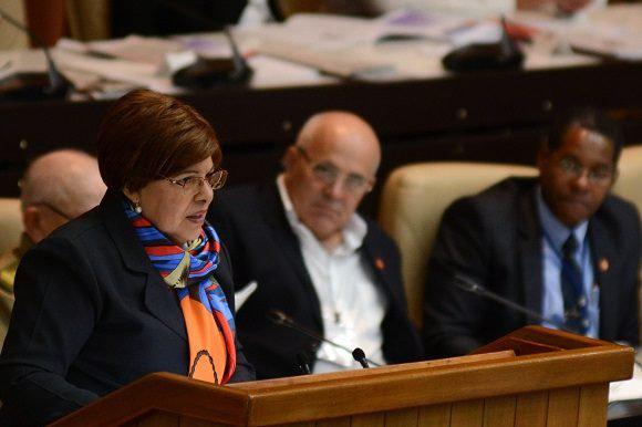 mujer habla, personas esuchan, tribuna, micrófono