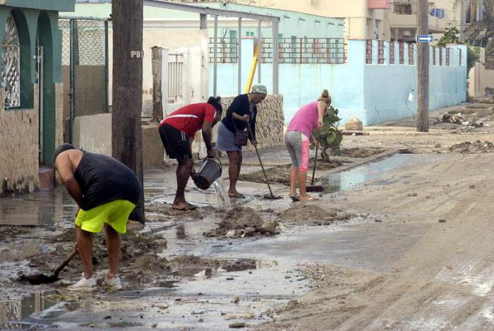 Personas limpiando las calles, luego de pasada la baja extratropical por La Habana.