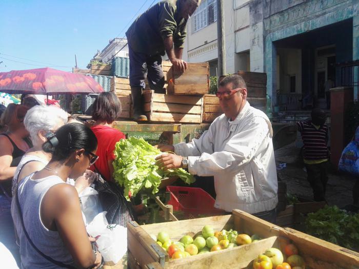 hombre vendiendo, mujeres compran, calle
