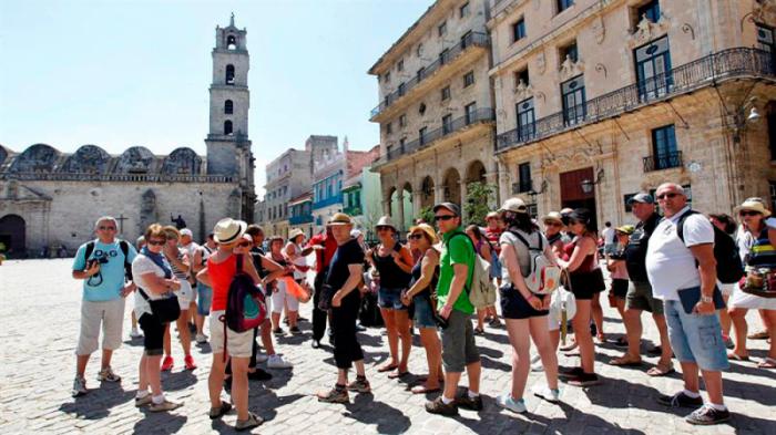 grupo de turistas caminan por las calles de la habana vieja.