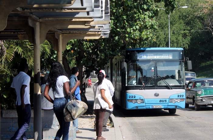 Personas en parada de omnibus en la habana, Cuba.