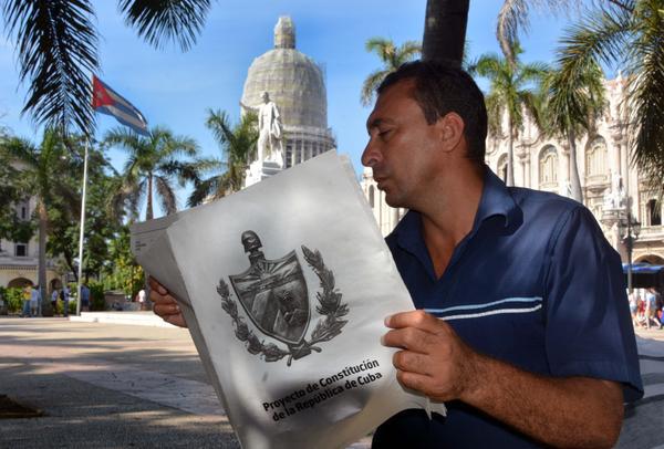 Hombre leyendo el proyecto de constitución de la república de cuba.
