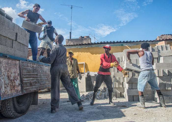 Estibadores descargan materiales de construcción para viviendas de damnificados por el tornado en La Habana