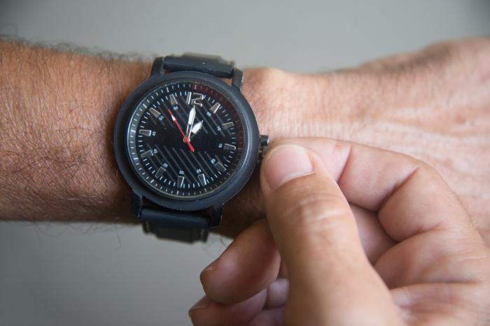 mano cambiando hora de reloj