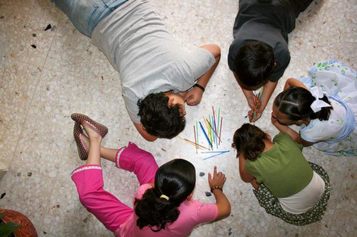 Niños jugando con palitos chinos.