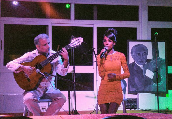 mujer cantando junto a hombre tocando guitarra