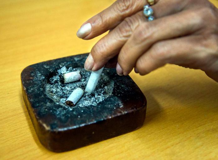 Persona apagando un cigarro.