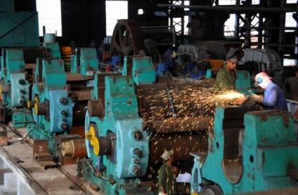 Un obrero labora en una fábrica, la cual debe ajustar sus producciones a las nuevas necesidades del país