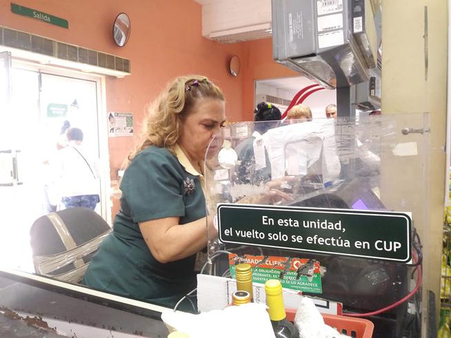 Cajera participa en el inicio de experimento de devolución de vueltos en moneda nacional