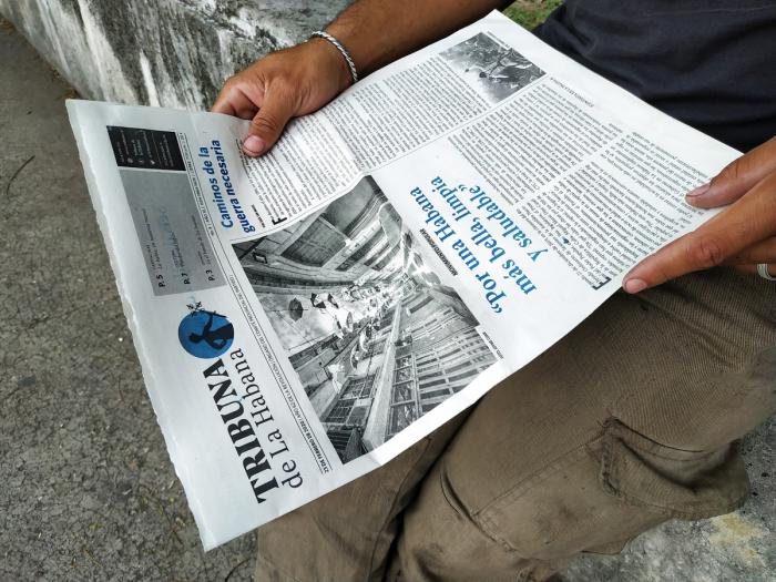 personas leyendo periodico tribuna