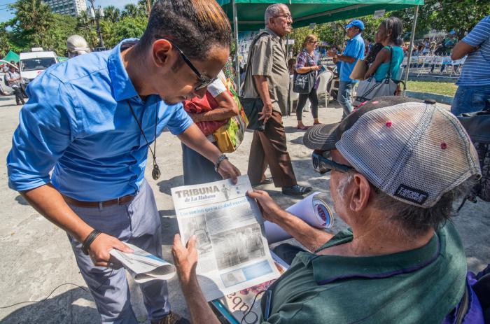 personas leyendo periodico tribuna