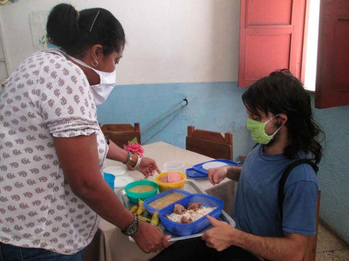 mujer ofreciendo alimentos a otra en sistema de atencion a la familia