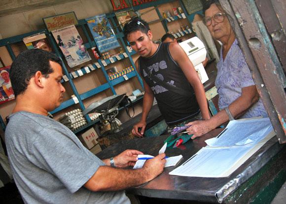 Bodeguero revisa libreta de abastecimiento