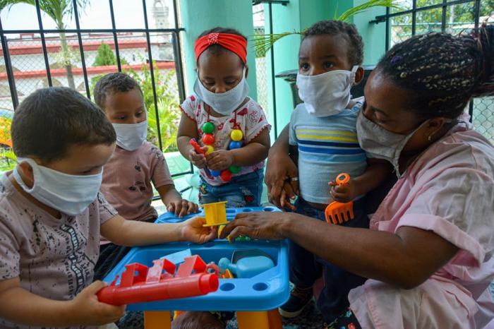 niños con nasobuco jugando en circulo infantil 