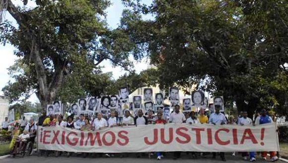 Familiares y otras personas recordando el crime de Barbados en 2018, con un cartel de Exigimos justicia y fotos de los fallecidos