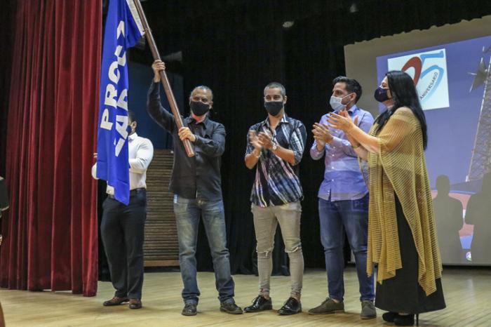 Varias personas con la bandera de proeza laboral
