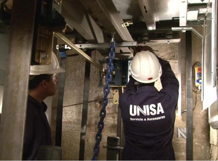 trabajadores haciendo sustitución de ascensores en edificios multifamiliares de La Habana