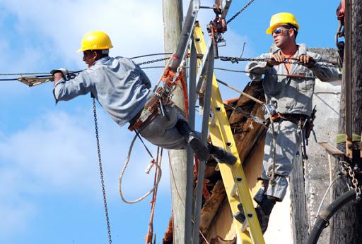 Trabajadores de servicio eléctrico en una escalera