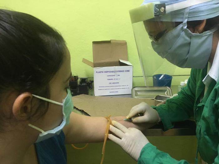 Técnica de laboratorio haciendo un análisis a una paciente