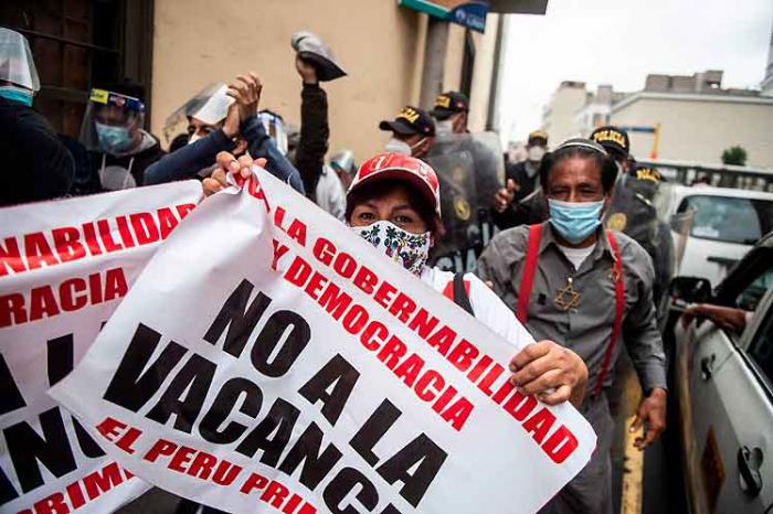 Personas con carteles en una manifestación de protesta en el Perú