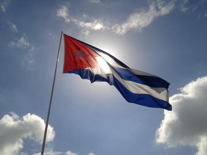 Bandera cubana con el cielo y el sol de fondo