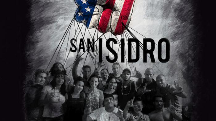 Miembros del movimiento San Isidro, una bandera de Estados Unidos con hilos que le cuelgan como para manipular a unas marionetas