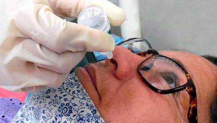 doctor poniendo gotas nasales a paciente