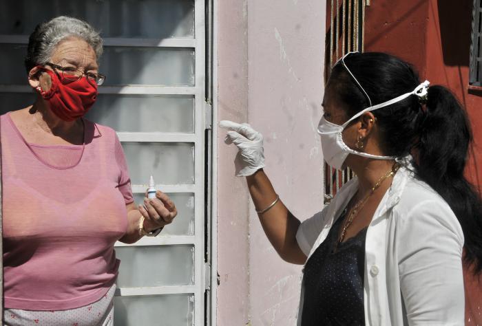 Una adulta mayor recibiendo un medicamento por personal de salud