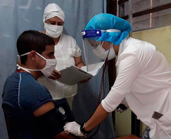 Médico atendiendo a paciente-covid-19 en Cuba