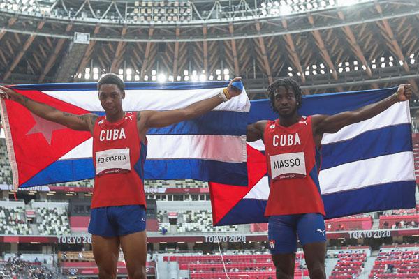 Juan Miguel Echevarría (I) y Maykel Massó (D) de Cuba tras ganar plata y bronce, respectivamente en la final del salto de longitud para hombres del atletismo en el Estadio Olímpico de Tokio durante los Juegos Olímpicos de Tokio 2020, en la capital Japón, el 2 de agosto de 2021. Foto: Roberto Morejón, periódico Jit, Inder.
