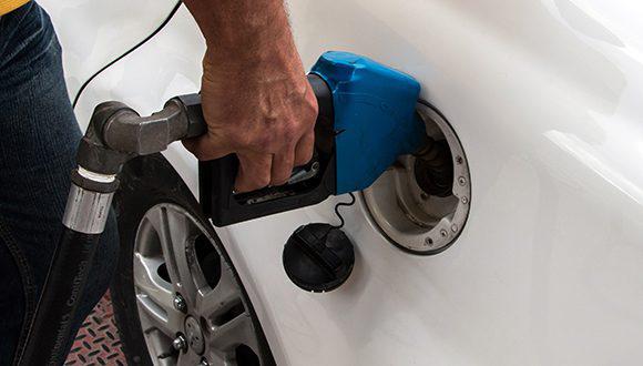Una persona que está echando gasolina en un tanque de un carro