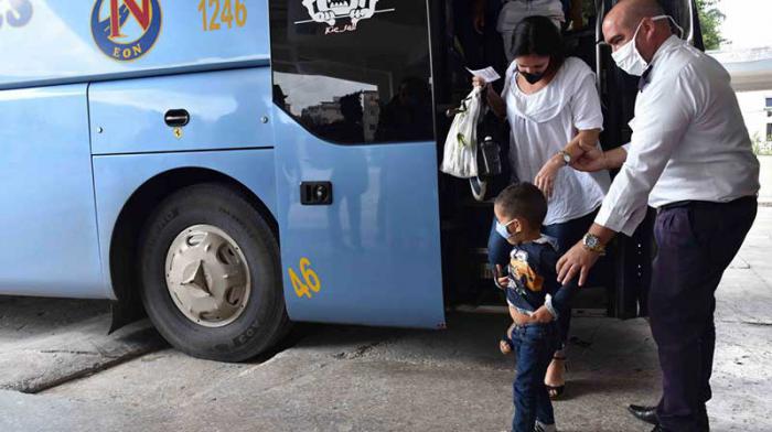 Una guagua de ómnibus nacionales con el conductor, un niño y su mamá