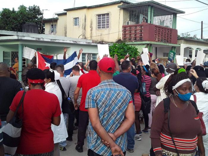 Población reunida en un acto frente a una miembro de Archipiélago