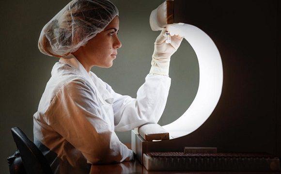 Científica en un laboratorio con una vacuna en la mano