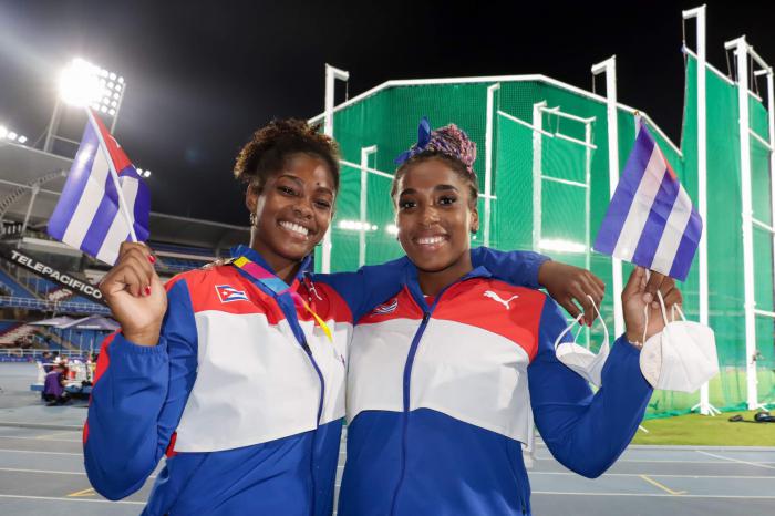 Dos deportistas cubanas con la bandera cubana