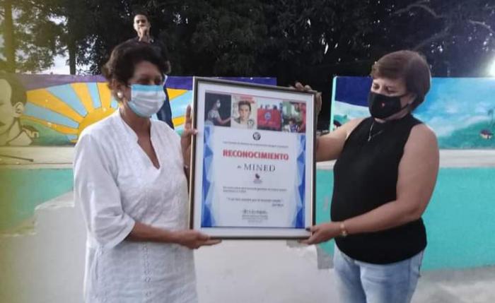 Julia Durruty Molina, integrante del Secretariado Nacional de los CDR entrega un reconocimiento a los educadores cubanos, lo recibe Ena Elsa Velázquez Cobiella, Ministra de Educación.