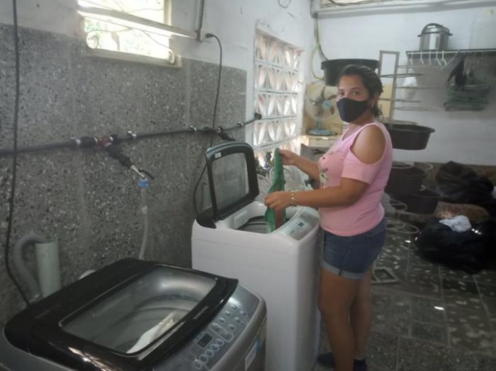 Daniuska Mercader Martínez lavando con una lavadora