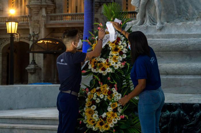 Jóvenes depositan una ofrenda floral frente a la estatua de José Martí en el Parque Central.