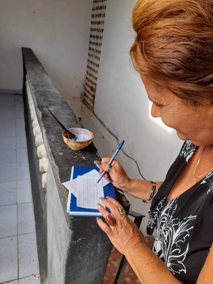 Una mujer llena un papel con sus datos